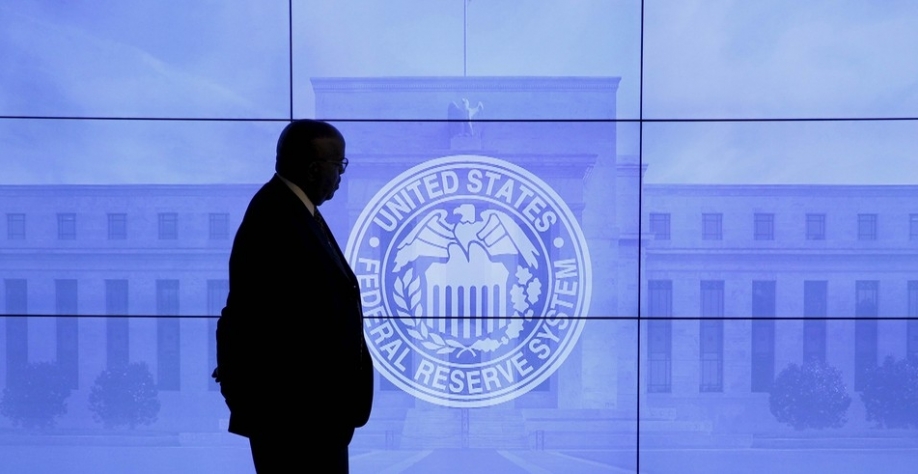  Segurança passa em frente a uma imagem do Fed após reunião do Fomc em Washington, nesta quarta (27) — Foto: Reuters/Kevin Lamarque