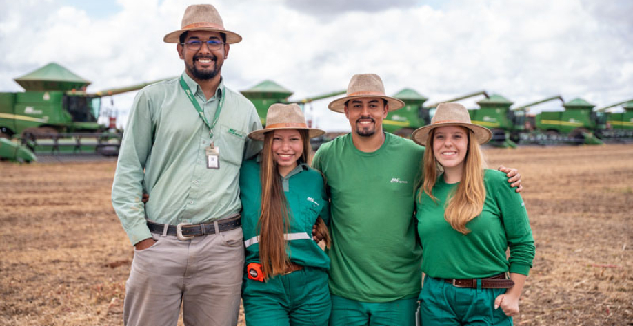 Colaboradores da SLC Agrícola a frente do maquinário da companhia