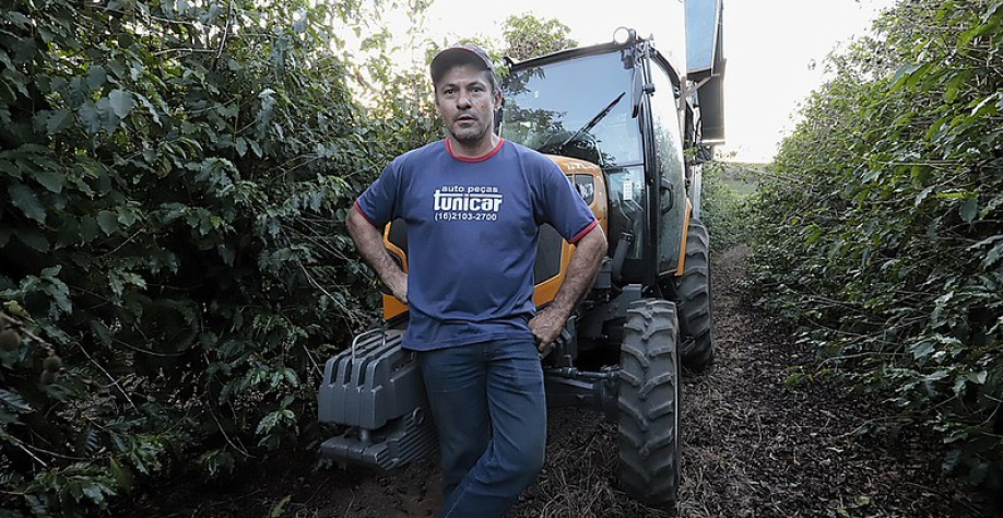 Fábio Theodoro Neves, cafeicultor na região de Franca, em seu cafezal com o trator adquirido com apoio do Pró-Trator